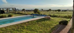a swimming pool in the middle of a field at Casita de campo con piscina in La Punta