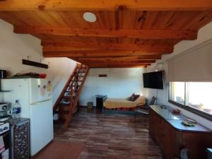 a kitchen with a white refrigerator and a table at El churqui in San Esteban