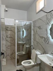 a bathroom with a toilet and a sink and a mirror at Les résidences Astou et Ndiaga in Dakar
