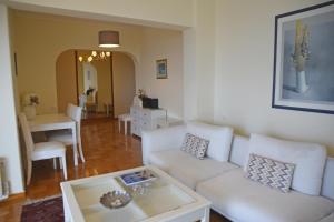 a living room with a white couch and a table at Athens Edem Beach Penthouse, panoramic sea view in Athens +24 photos