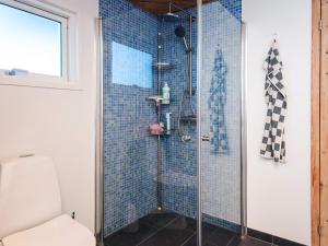 a bathroom with a shower with blue tiles at Panoramic Fjord Retreat with Spa Bath in Øster Assels +45 photos