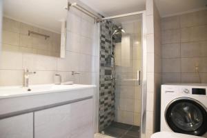a bathroom with a sink and a washing machine at Athens Edem Beach Penthouse, panoramic sea view in Athens