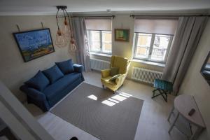 sala de estar con sofá azul y silla amarilla en Poduszka Apartamenty Kamienica, en Pasłęk