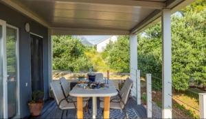 eine Terrasse mit Tisch und Stühlen auf einer Veranda in der Unterkunft Private Resort Lumianni- 2 Houses in Kaštela