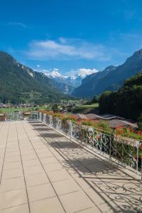 uma varanda com flores e vista para as montanhas em Waldhotel Unspunnen em Interlaken