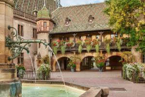 a water fountain in the courtyard of a building at L'ambassadeur - Colmar centre in Colmar