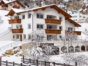 una casa nella neve con una recinzione di Villa Otto a Santa Cristina in Val Gardena