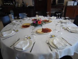 a white table with plates of food and wine glasses at Domus Viatoris in Sahagún