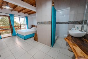 un bagno con un lavandino e un letto in una stanza di Hotel Nantu Hostería a Puerto López