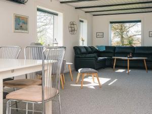 a living room with a couch and a table and chairs at 5 person holiday home in Snedsted in Snedsted