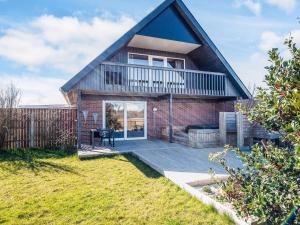 a brick house with a patio in the yard at 12 person holiday home in Thyborøn-By Traum in Thyborøn