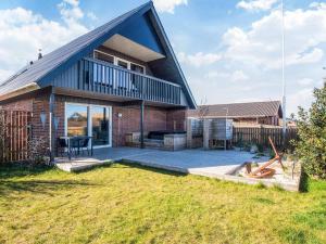 a brick house with a black roof and a patio at 12 person holiday home in Thyborøn-By Traum in Thyborøn