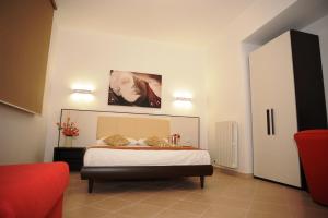 a bedroom with a bed and a red couch at Bed & Breakfast Villa Corallo Parcheggio privato in Porto Cesareo