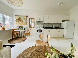 a kitchen with white cabinets and a table and chairs at Cozy Coach House in Kitchener