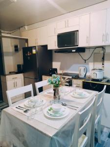 a kitchen with a table with plates and flowers on it at De Richness in Tagbilaran City
