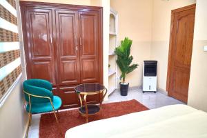 a room with a bed and two chairs and a door at Levels Guest Home in Yaoundé +8 photos