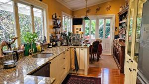 a kitchen with yellow walls and counters and windows at The Grange in Auckland