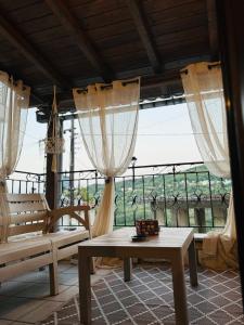 a living room with a table and a large window at Philoxenia Guest House in Makrirrákhi
