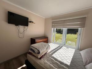 カブルグアにあるcasa amplia, parcela exclusiva, para 14 personasのベッドルーム(ベッド1台、テレビ、窓付)