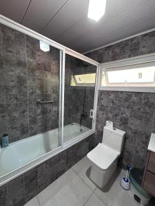 カブルグアにあるcasa amplia, parcela exclusiva, para 14 personasの浴槽、トイレ、洗面台を備えたバスルーム +34枚の写真