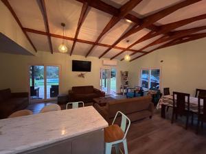 カブルグアにあるcasa amplia, parcela exclusiva, para 14 personasの木製の天井のリビングルーム、テーブル付きのリビングルーム