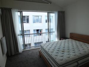 ウェリントンにあるHidden Hideaway With Harbour View - Prime locationのベッドと大きな窓のある寝室