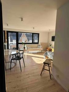 ein Wohnzimmer mit Tisch und Stühlen und einer Couch in der Unterkunft Studio cosy in Armentières