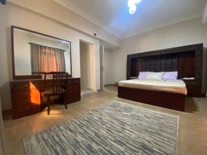 a bedroom with a bed and a desk and a mirror at Comfortable 3BR New Cairo Prime Spot in Cairo