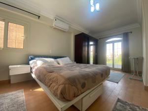 a bedroom with a large bed in a room with windows at Comfortable 3BR New Cairo Prime Spot in Cairo