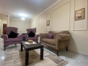 a living room with two chairs and a table at Comfortable 3BR New Cairo Prime Spot in Cairo