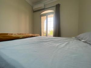 a large bed in a room with a window at Comfortable 3BR New Cairo Prime Spot in Cairo