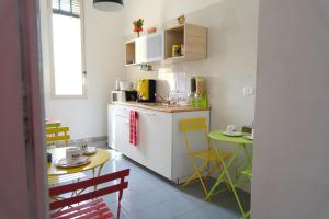 B&B Tarumbò في نابولي: مطبخ مع كونتر وطاولة مع كراسي