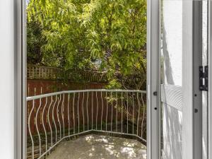 an open door to a balcony with a tree at Terrace Townhouse - Prime location & Free Parking! in Wellington +3 photos