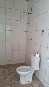 a bathroom with a white toilet and a sink at Area de Lazer Isah in Araraquara