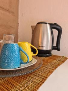 a coffee pot and two cups on a table at Chalé À800Mts do Parq Chapada dos Veadeiros, Wi-fi in Alto Paraíso de Goiás