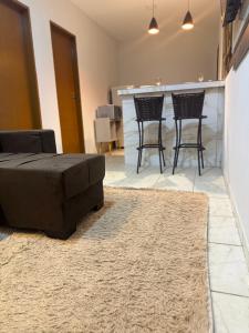 a living room with a couch and two chairs at Flat mobiliado in Arapiraca