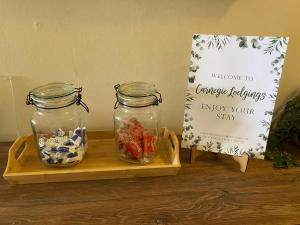 two glass jars on a wooden tray with a sign at Carnegie Lodgings, Tain in Tain