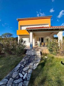 ein Haus mit einem steinernen Gehweg davor in der Unterkunft Holiday house with a parking space Supetarska Draga - Donja, Rab - 24284 in Rab