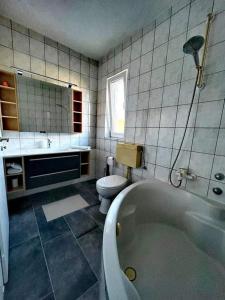 ein Badezimmer mit Toilette und Badewanne in der Unterkunft Holiday house with a parking space Supetarska Draga - Donja, Rab - 24284 in Rab