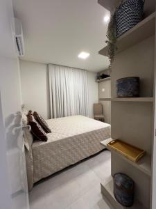 En eller flere senge i et værelse på Apartamento Luxo 3 suítes