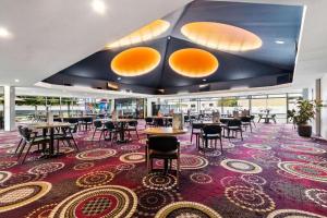 a restaurant with tables and chairs on a large rug at Beach Holiday Home-Close to Airport-3 Bed & 2 Bath in Lauderdale