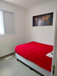 a white room with a bed with a red blanket at Apartamento campolim 2 quartos in Sorocaba