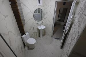 a bathroom with a toilet and a sink and a mirror at Hôtel Family Ouargla in Ouargla