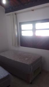 a bedroom with a bed in front of a window at Quarto Navegantes in Porto Seguro +2 photos