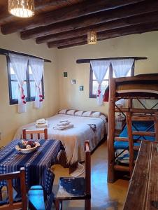 a bedroom with a bed and a table and chairs at Los Amarantos in Tilcara