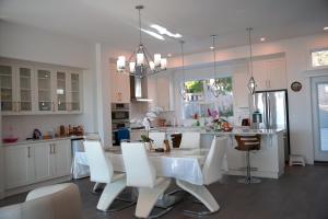 a kitchen with a white table and white chairs at Modern Zen House, EV Plugin, Mountains, Trails & Stylish Urban Vibe in Coquitlam