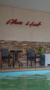 サン・クレメンテ・デル・トゥユにあるAltair Hotelのスイミングプール(椅子、テーブル、看板付)