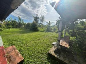 a view of a field of grass with a bench at New Waroeng Tenggale in Mambat