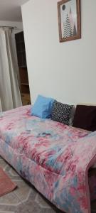 a bed with a colorful comforter in a bedroom at Dulce Adelina II Zona Céntrica in Río Grande +8 photos