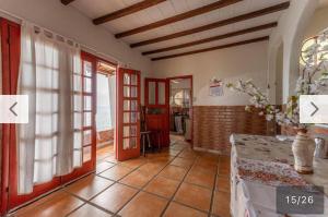 a living room with red doors and a tile floor at Refúgio a beira Ilha de itacuruça RJ in Ilha de Itacuruçá +10 photos
